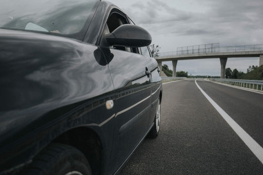 A car with a high performing battery driving on the highway