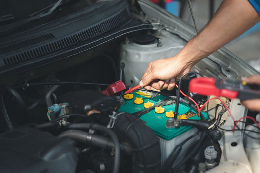 A technician checking a failing car battery
